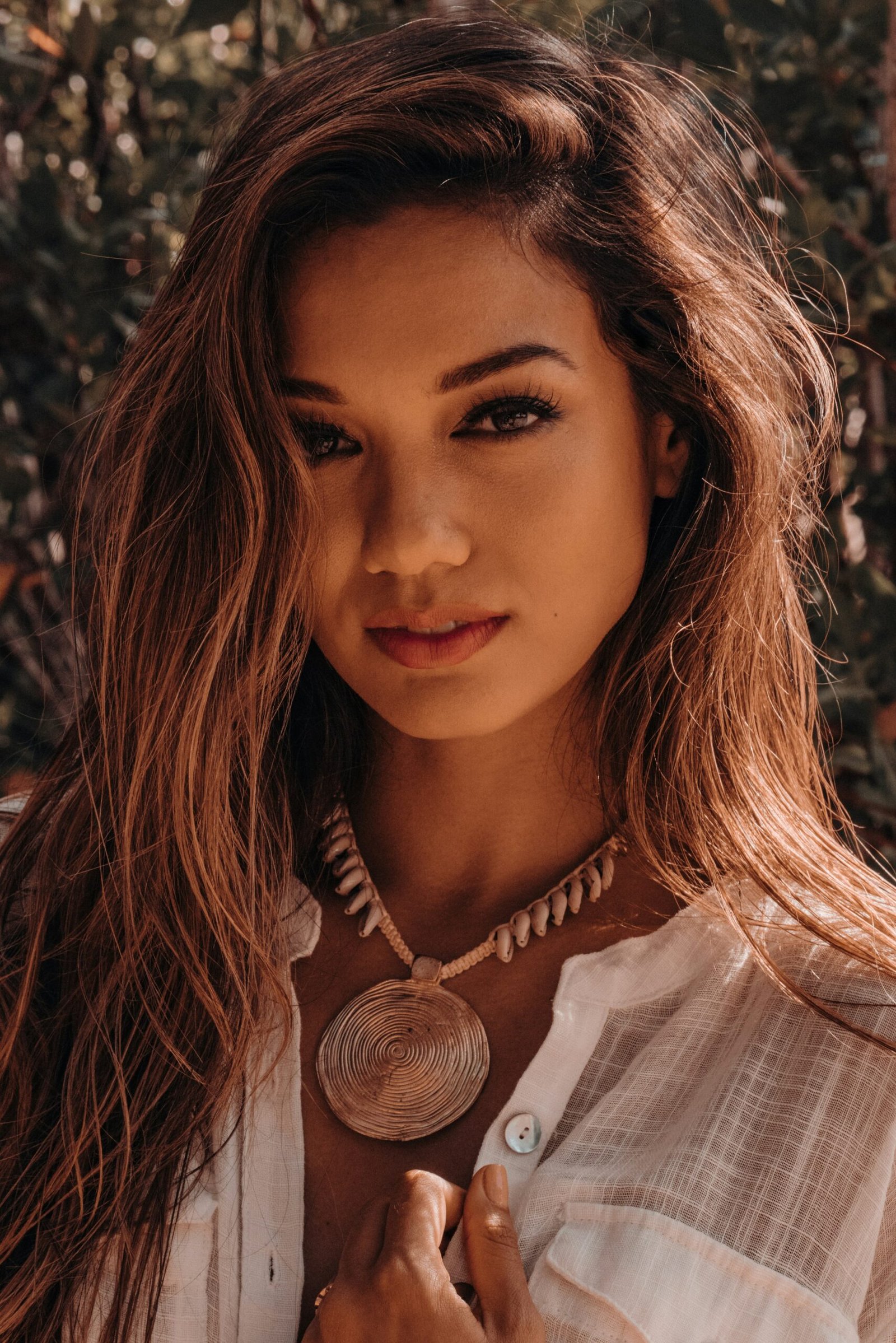 a woman wearing a necklace and a white shirt